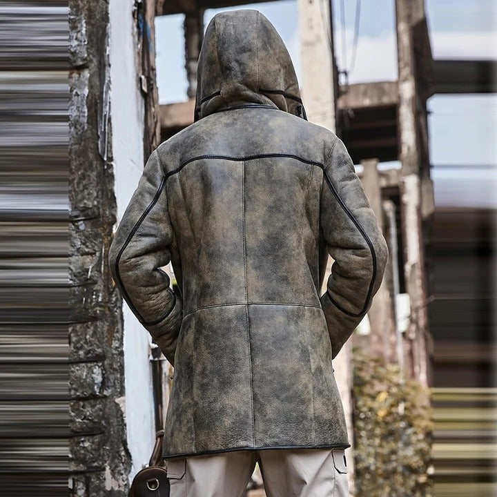 Person wearing a hooded leather coat in an industrial setting