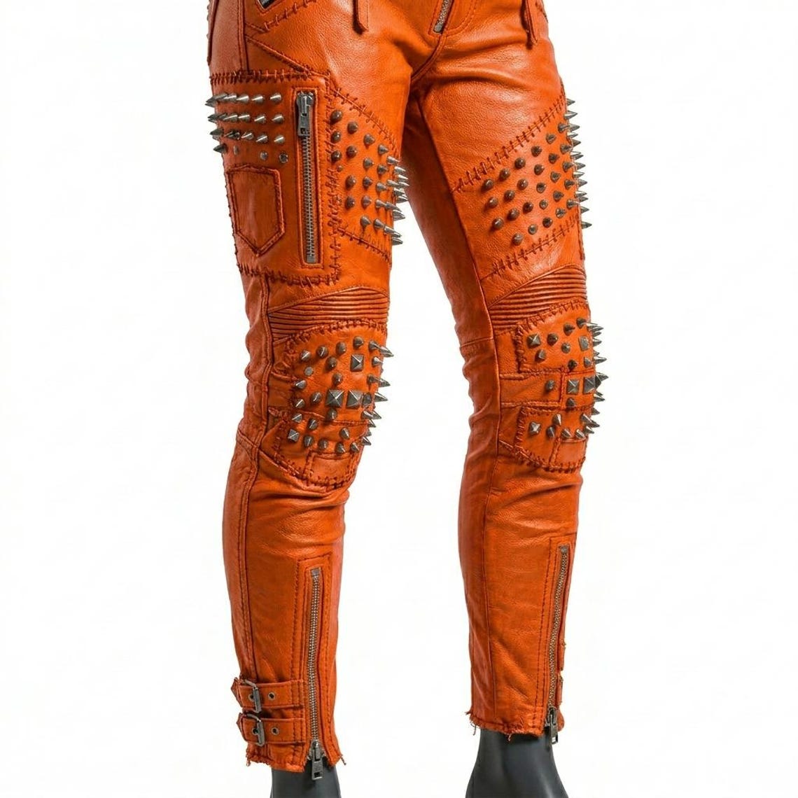 Close up of gothic orange leather trouser with spike hardware