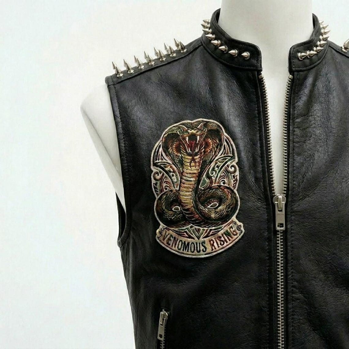 Close up of metal stud detailing on men black leather biker vest